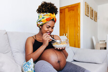 Cheerful Pregnant Woman Eating Cereals With Milk