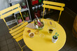 © ByLorena/Stocksy - Round table and yellow chairs with salad and coffee