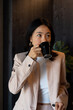 © Bisual Studio/Stocksy - Asian businesswoman drinking coffee in office