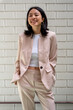 © Bisual Studio/Stocksy - Optimistic Asian businesswoman with hands in pockets