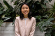 © Bisual Studio/Stocksy - Asian businesswoman resting near lush plants