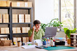 © ALTO IMAGES/Stocksy - Friendly post office worker making phone call