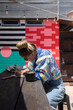 © Shava Cueva/Stocksy - Young woman wearing a retro jacket writing on a wooden table