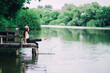 © Balazs Kovacs/Stocksy - woman sitting on a pier by a lake