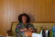 © Raymond Forbes LLC/Stocksy - African American Couple laughing and smiling  together on couch