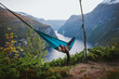 © Alina Miluseva/Stocksy - Man sleeping in hammock above Geirangerfjord in Norway