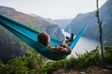 Man Resting In Hammock Above Geirangerfjord In Norway