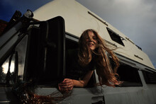 A Girl Leans Out Of The Window Of A Camper Van