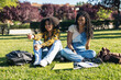 © Pedro Merino/Stocksy - Students sitting on a lawn at the university