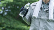 プラスチックボトルの水を飲む作業服の男性｜建設業の熱中症対策イメージ