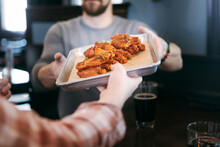 Brewery: Server Hands Tray Of Hot Wings To Customer