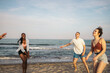 © Pedro Merino/Stocksy - Group of friends playing and enjoying on the beach