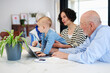 © Guille Faingold/Stocksy - Grandparents and mom supporting baby