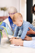 © Guille Faingold/Stocksy - Baby using laptop with grandparents and mother