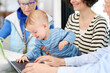 © Guille Faingold/Stocksy - Baby using netbook near family
