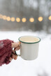© Léa Jones/Stocksy - hand holding a coffee cup in snow