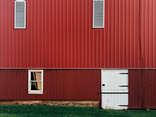 Detail Of Exterior Of Side Of A Red Barn With Green Grass