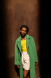 © Alba Vitta/Stocksy - Fashionable African model front rusty iron wall at city