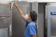 © Javier Pardina/Stocksy - nurse with facemask, working with  Washer Disinfector Machine.