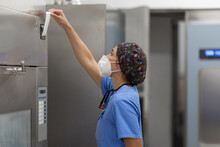 Nurse With Facemask, Working With  Washer Disinfector Machine.