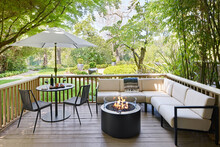Outdoor Furniture Sitting Area And Fireplace On Backyard Deck Of Hotel
