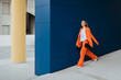 © Mauro Grigollo/Stocksy - Fashionable woman walk out from a building