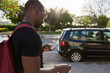 © Javier Díez/Stocksy - Serious black man with suitcase standing on street