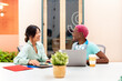 © Santi Nuñez/Stocksy - Smiling women talking in a casual office
