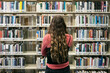 © Sean Locke/Stocksy - Student Looking At Bookshelves In Library