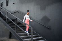 Happy Black Sportswoman Walking Downstairs On Street