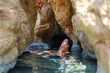 © ZHPH Production/Stocksy - Young woman relaxing in natural spring