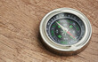 © boommaval - round compass on wooden background. symbol of tourism with a compass. concept travel with compass