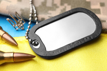 Wall Mural - Military ID tag near Ukrainian trident, bullets and camouflage fabric on national flag of Ukraine, closeup
