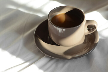 Wall Mural - Cup of aromatic coffee on bed in morning, closeup