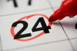 © Grustock - The calendar 24th day of the month is circled. A red marker circles the twenty-fourth day of the month from the paper calendar. A very important date in the calendar