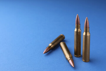 Wall Mural - Bullets on blue background, closeup. Space for text