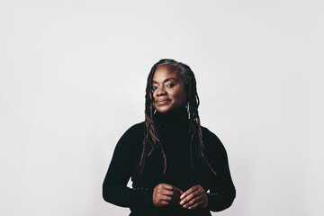 confident woman with dreadlocks looking at the camera in a studio