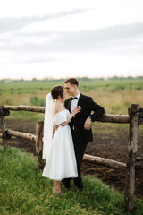 young couple the groom in a black suit and the bride in a white short dress