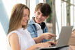 © Egoitz - Teenager students working together on laptop. Boy and girl learning in a hall