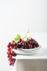 Poster - Red grape on the white linen tablecloth