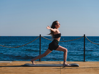 young woman doing yoga on the beach