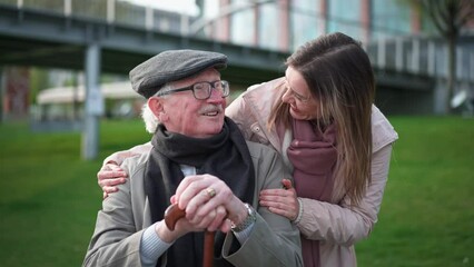 Wall Mural - Happy senior man with his adult daughter sitting outdoors in park.