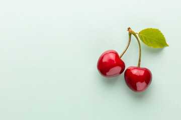 Wall Mural - Cherry berries on a pastel background top view.  Background with a cherry on a sprig, flat lay