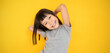 © paulaphoto - Portrait of young happy little asian girl in gray t shirt isolated on yellow background with copy space. Education for toddler or preschool, childhood lifestyle back to school concept