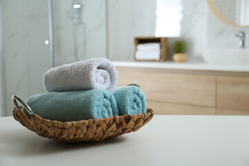 Poster - Wicker tray with clean soft towels in bathroom. Space for text