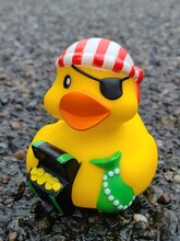 Vertical Closeup Shot Of A Pirate Rubber Duck Toy On The Ground