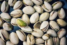 A Closeup View Of A Single Pistachio Seed Open With Another Within A Pistachio Shell