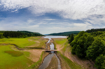 Wall Mural - Aerial view of a near empty reservoir and old bridge during a UK heatwave (Llwyn Onn)