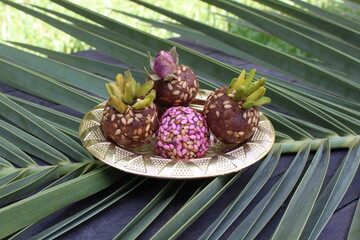 Healthy date fruit energy bliss balls with sesame seed on palm background