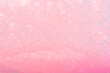 pink soap suds background closeup